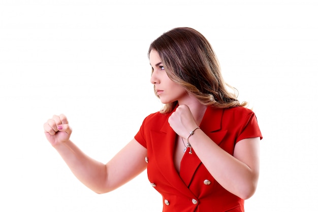 Serious young woman in a red costume on a white background.