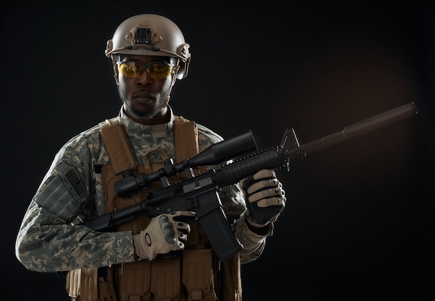 Seriously American soldier in uniform holding modern weapon.