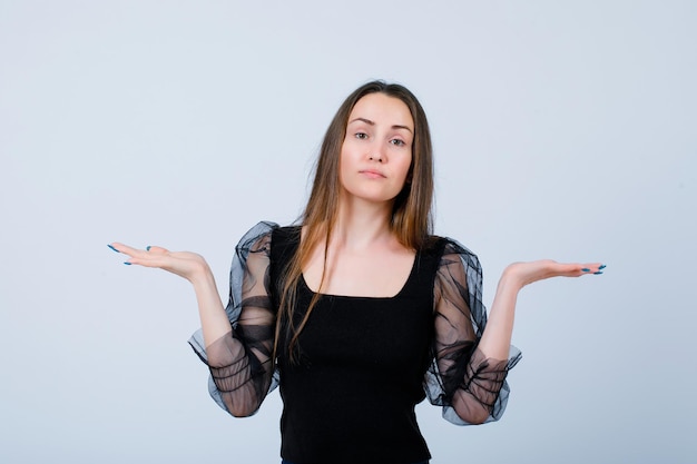 Seriously girl is opening wide ehr hands on white background