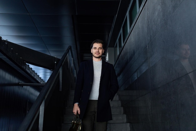 Seriously strong male businessman descends the stairs of the business center