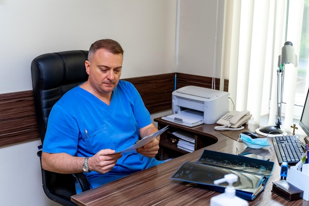 Seriuos male doctor reading medical diagnosis Sitting in cabinet Modern interior office background