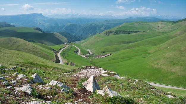 녹색 산에 구불구불한 자동차 도로 구불구불한 도로가 있는 산악 지역의 풍경