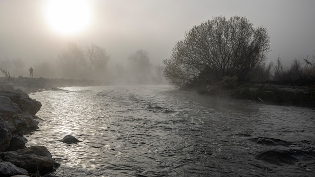 Serpis rivier bij zonsopgang zeer kalm en mistig met een man aan de linkerkant.