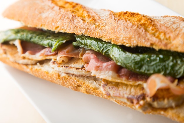 Photo serranito sandwich typical spanish sandwich with pork loin bacon and fried green pepper