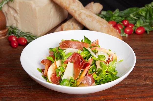 Serrano Ham Watercress Salad는 아라비아 음식의 탁자 위에서 분리된 접시에 제공됩니다.