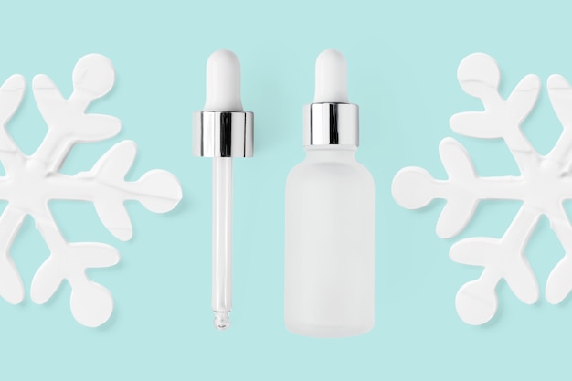 Serum bottle with pipette and snowflake shape cream moisturizer smudges