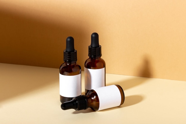 Serum en etherische cosmetische oliefles met druppelaar met schaduwen op de achtergrond Cosmetisch spaproduct en huidverzorgingsdruppelaar op beige achtergrond