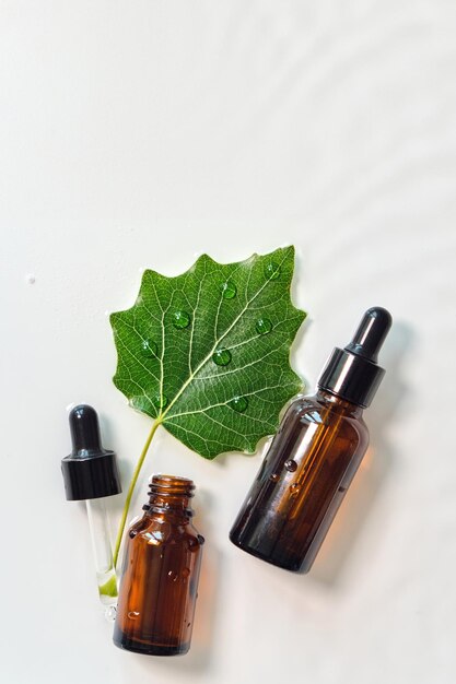 Serum in glass bottle on white wet texture background