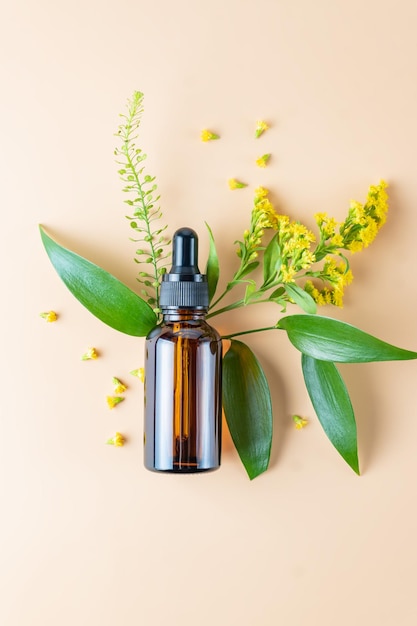 Serum glazen fles met pipet en mooie bloemen op de beige achtergrond Natural Organic Spa Cosmetic concept Bovenaanzicht