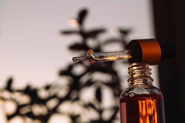 serum in een glazen fles op een natuurlijke achtergrond etherische olie voor huidverzorging