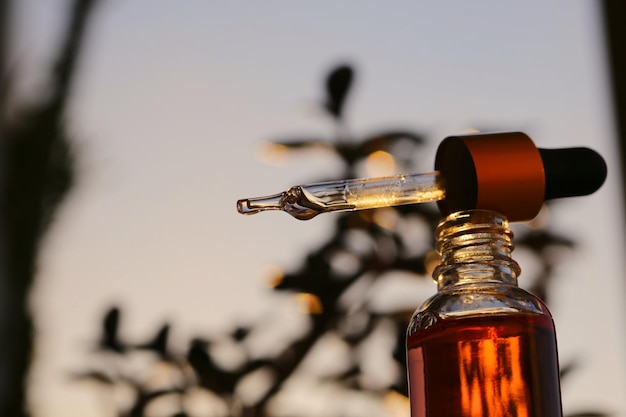 serum in een glazen fles op een natuurlijke achtergrond etherische olie voor huidverzorging