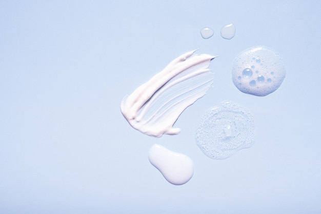 serum and moisturizing smears cosmetic cream with on colored background top view