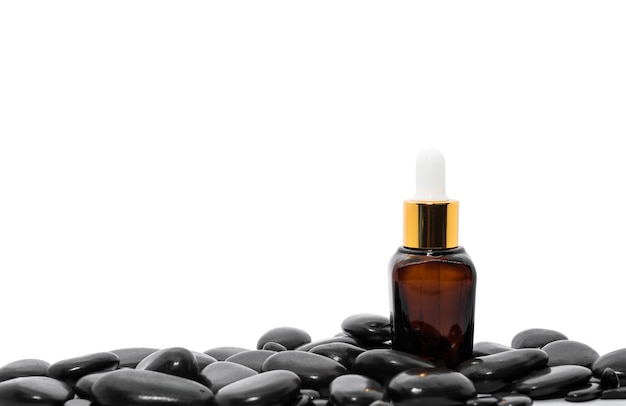 Contagocce bottiglia di olio di siero mock up o olio essenziale con pietra nera su sfondo bianco
