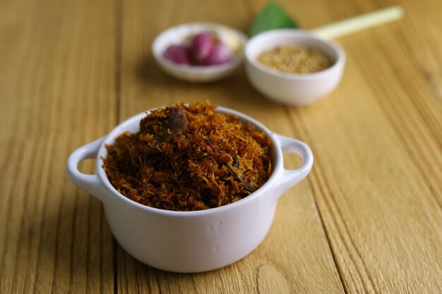 Serundeng or saur Indonesian spicy coconut flakes made from sauted grated coconut with spices