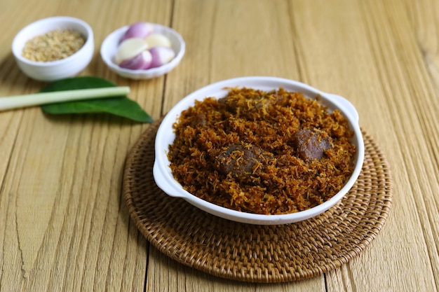 Serundeng or saur Indonesian spicy coconut flakes made from sauted grated coconut with spices