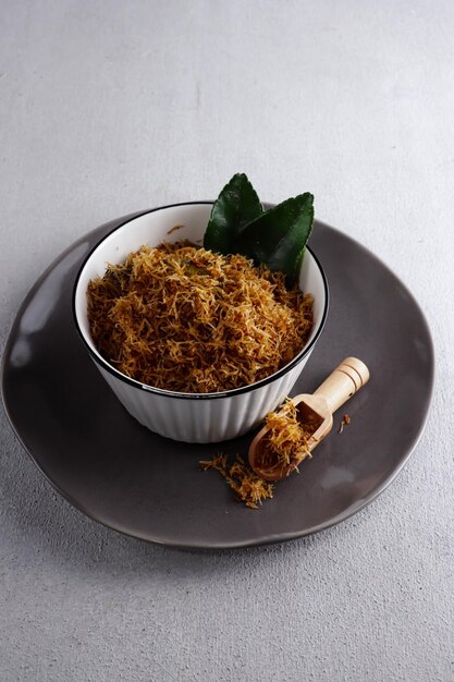 Serundeng or saur Indonesian spicy coconut flakes made from sauted grated coconut with spices