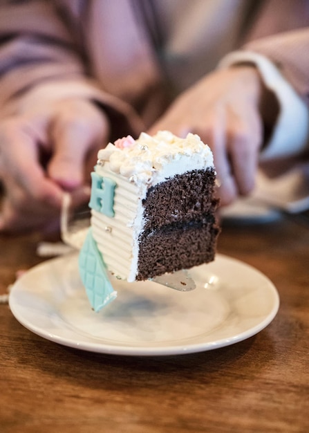 白い皿にホイップクリームをトッピングしたピースチョコレートケーキを誕生日に祝う