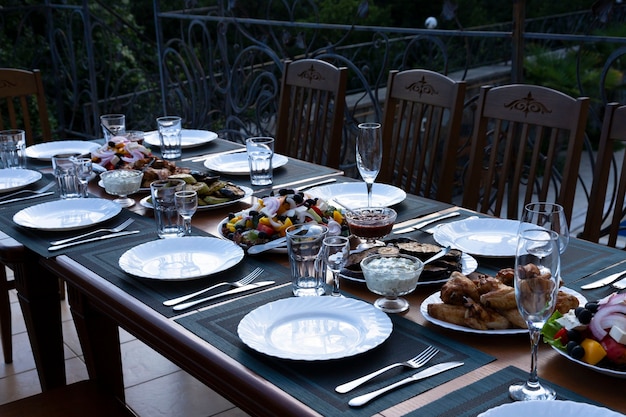 Served banquet, dining table with dishes, snacks, glasses for wine and water, European cuisine. Selective focus.