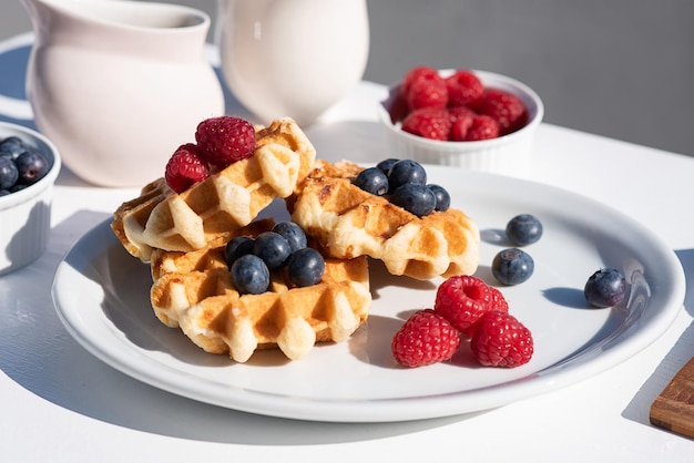 Served breakfast on the street waffles with berries on a white plate