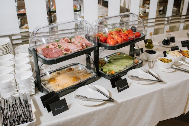 Served buffet table with vegetables, cheese and meat indoor the restaurant