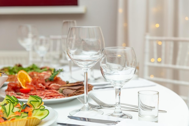 Served for holiday banquet restaurant table with dishes snack cutlery wine and water glasses