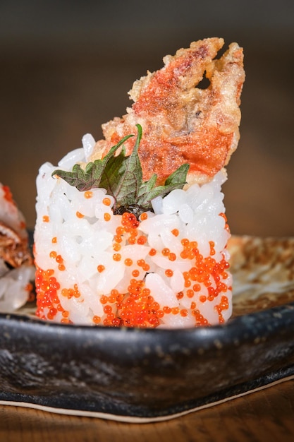 Served restaurant dish of Japanese cuisine of tobiko uramaki with deep fried crab claw