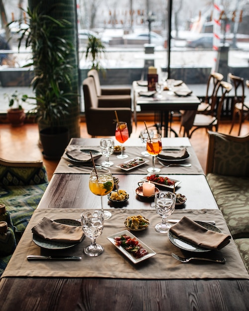 Served restaurant table with aperitif cocktails and mediterranean appetizers