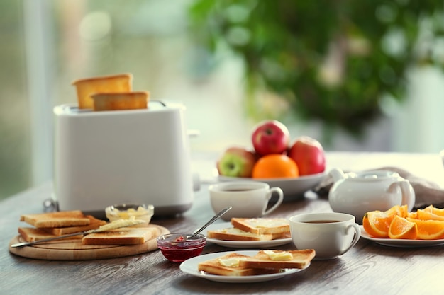 ぼやけた背景にトーストコーヒーとフルーツと朝食用のテーブルを提供