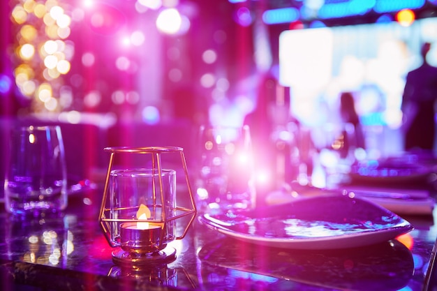 Served table of a night club against the background of multicolored lights