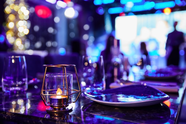 Served table of a night club against the background of multicolored lights