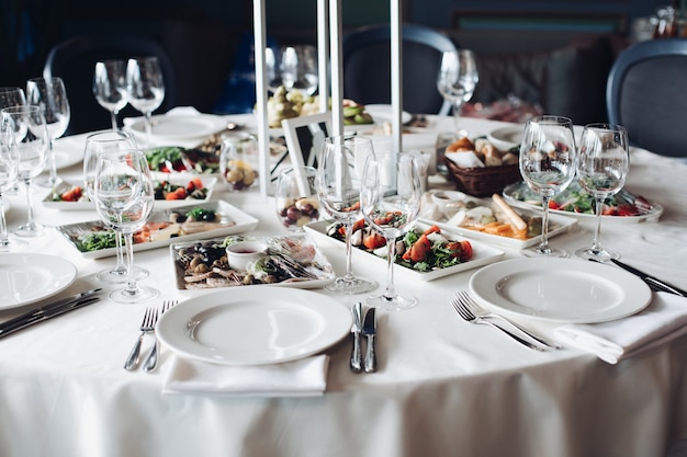 Served table with snacks and empty wine glasses.