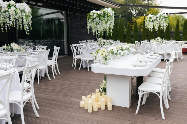 Served wedding table with decorative fresh white flowers and candles Celebration details