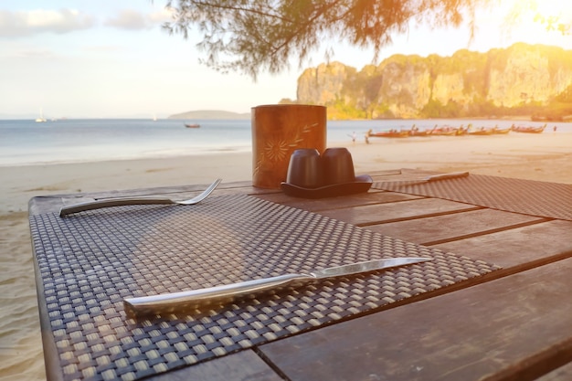 Tavola di legno servita su una spiaggia tropicale preparata per la colazione vicino al mare