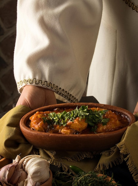 Serveerster die een kippenstoofpot voorstelt