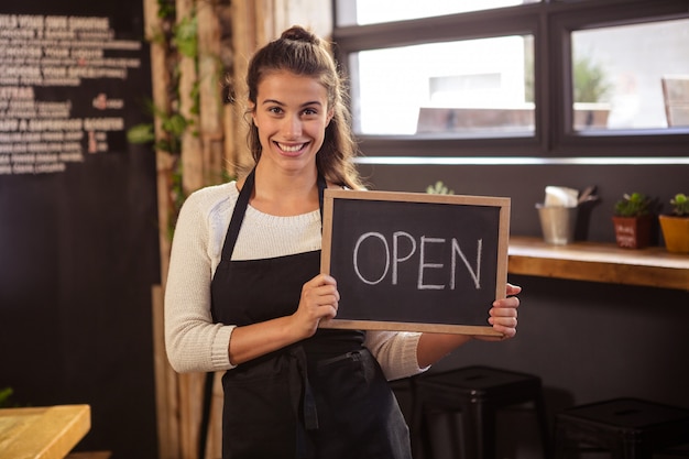 Serveerster die een teken met open houdt