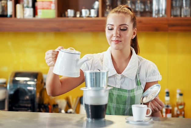 Serveerster die Vietnamese koffie maakt