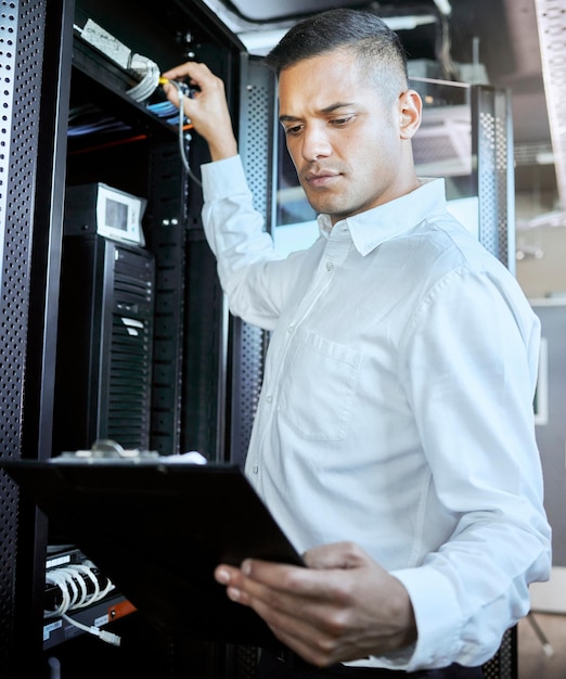 Server room database and IT support with a man programmer working on an information storage solution Documents cybersecurity and cloud computing with a male coder at work in a data center