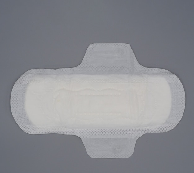 Servet sanitair. Zacht en comfortabel maandverband en grijze achtergrond. Wit bovenblad. Studio-opname geïsoleerd. Stoffen pads voor menstruatie. Vleugeltype voor de nacht. Snelle absorptie. katoen zacht gevoel.