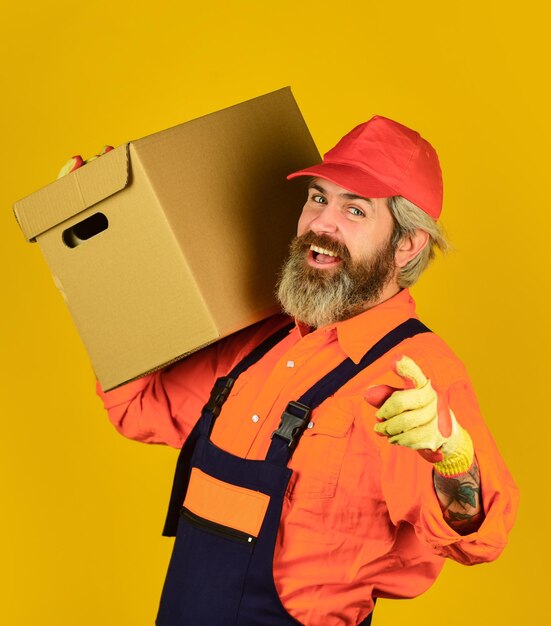 Service delivery Courier and delivery Postman delivery worker Handsome man red cap yellow background Delivering purchase Shopping Bachelor day Post worker Delivered to your destination