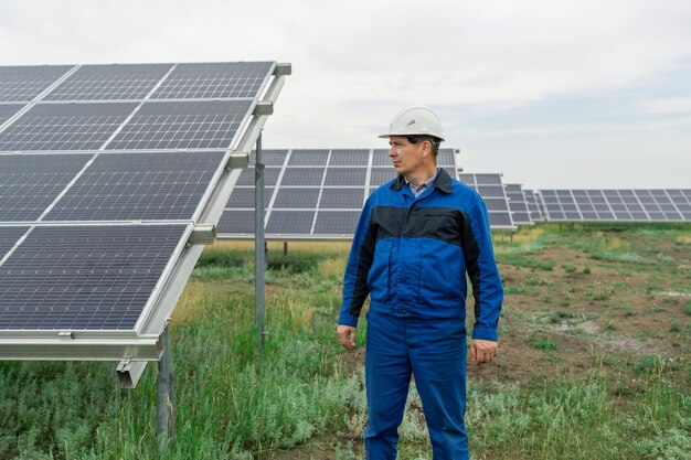 Foto service ingenieur man die voor zonnepanelen staat onderhoudstechnicus zonnepaneel op zonne-e