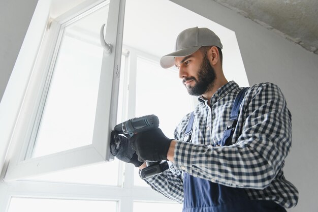 Photo service man installing window with screwdriver