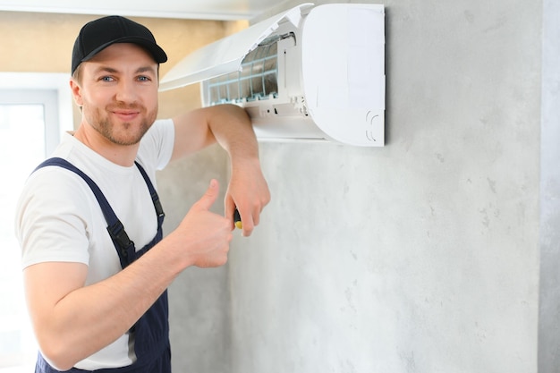 Photo service man is cleaning repair and maintenance of air conditioner