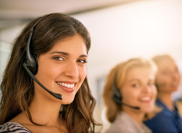 Service with a smile Cropped portrait of a young woman working alongside her colleagues in a call center