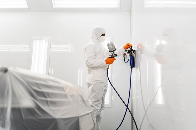 Photo service worker painting car in auto service