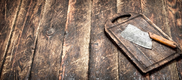 Serving background. Old hatchet on a chopping Board. On a wooden table.