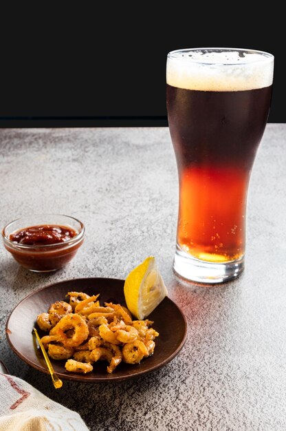 Serving beer with shrimps Dark beer and fried prawns Beer with foam