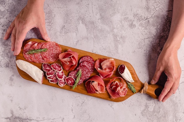 Photo serving board with a set of different meat snacks, top view.