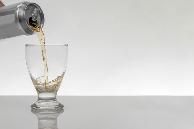 Serving a can of beer in a crystal glass with a white background and copy space