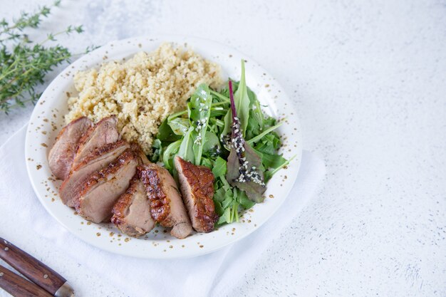 Serving couscous with salad and roasted duck breasts