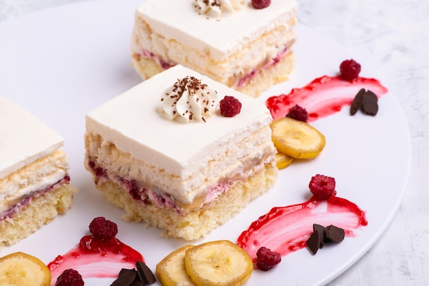 Serving of delicious fruit vanilla cake pieces on a white plate